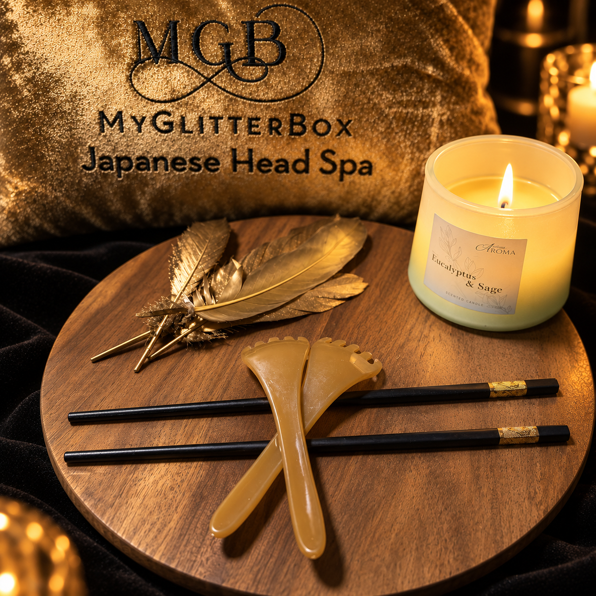 Gold ASMR hair play tools and tapping sticks displayed beside a candle at GlitterBox Head Spa in Stafford.